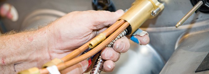 Plumber attaching dishwasher